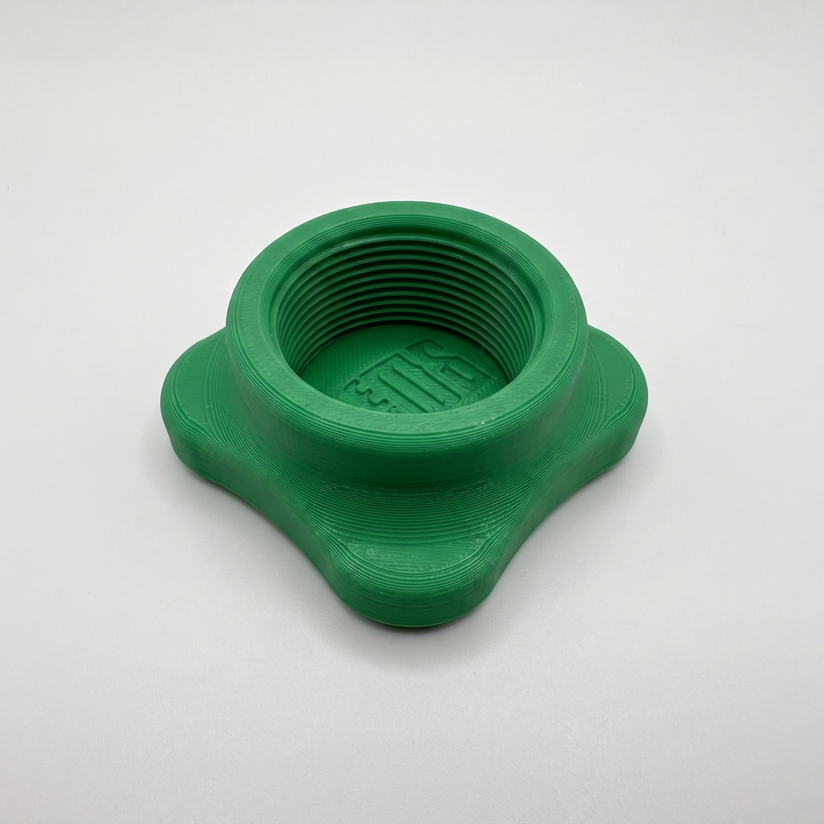 A green 3D-printed threaded component, a bottle opener